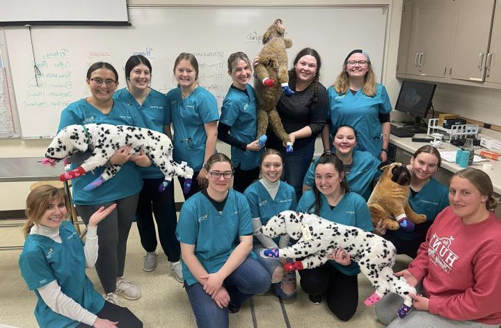 students in scrubs posing with stuffed animal dalmations 